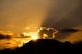 Beautiful sunrise cloud and beam of sun in the morning with silhouette of roof and treetops