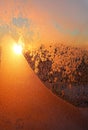 Beautiful sunrise and ice patterns on winter window pane Royalty Free Stock Photo