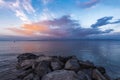 Beautiful sunrise on the lake with colorful clouds and stones on the shore. Armenia Sevan lake