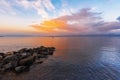 Beautiful sunrise on the lake with colorful clouds and stones on the shore. Armenia Sevan lake