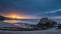 Beautiful sunrise landscape image of Kennack Sands in Cornwall UK wuth dramatic moody clouds and vibrant sunburst