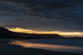 Beautiful sunrise landscape image of Kennack Sands in Cornwall UK wuth dramatic moody clouds and vibrant sunburst