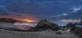 Beautiful sunrise landscape image of Kennack Sands in Cornwall UK wuth dramatic moody clouds and vibrant sunburst