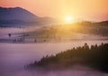 Beautiful sunrise in the mountains. The rays of the final light through the coniferous trees in the forest on the mountains. incre