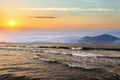 Beautiful sunrise in mountains with white fog below and crashing waves of lake water