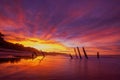 Beautiful sunrise of old jetty piles at St. Clair Beach in Dunedin, New Zealand