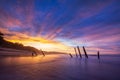 Beautiful sunrise of old jetty piles at St. Clair Beach in Dunedin, New Zealand
