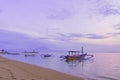 Beautiful sunrise and old wooden fishing boats view from Sanur beach, Bali island. Footprints in the sand