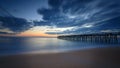 Beautiful sunrise over the Atlantic Ocean with a wooden pier in the background Royalty Free Stock Photo