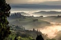 Beautiful sunrise over misty landscape of Italy. Early morning over rural area with gardens, fields in Tuscany province Royalty Free Stock Photo