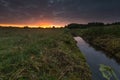 Beautiful sunrise over misty meadow and stream Royalty Free Stock Photo