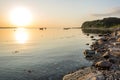 Beautiful sunrise over peaceful bay at the Baltic Sea with small boats and rocky shore Royalty Free Stock Photo