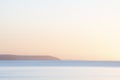 Beautiful sunrise over Pentewan Sands in Cornwall with pastel sky and long exposure ocean Royalty Free Stock Photo