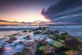 Sunrise cloudscape over sea waves and rocky beach shore, wild coastline and ocean horizon.