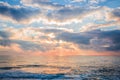 Beautiful sunrise over the sea. Sun beams break through the clouds. Royalty Free Stock Photo