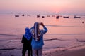 Beautiful sunrise. People enjoy the sunrise. Fishing boat silhouette with orange sunrise sky and water reflection