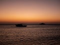 Beautiful sunrise on the Red Sea in Egypt. Dark silhouettes of yachts on the horizon