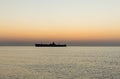 Beautiful sunrise at sea. The silhouette of an abandoned wreck in the sea