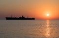 Beautiful sunrise at sea. The silhouette of an abandoned wreck in the sea