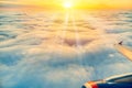 Beautiful sunrise sky above clouds with aircraft wing and engine. View from airplane window Royalty Free Stock Photo