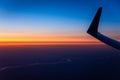 Beautiful sunrise sky above clouds with aircraft wing. View from airplane window Royalty Free Stock Photo