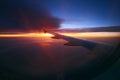 Beautiful sunrise in the sky during the flight. Plane wing above the cloudy colorful sunset Royalty Free Stock Photo