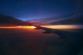 Beautiful sunrise in the sky during the flight. Plane wing above the cloudy colorful sunset Royalty Free Stock Photo