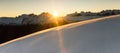Beautiful sunrise in snowy mountain landscape. Sunbeams illuminating unspoiled powder snow. Alps, Switzerland. Royalty Free Stock Photo