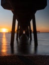 Beautiful sunrise under Deal Pier and the shadow pattern created in the water Royalty Free Stock Photo