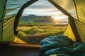 Beautiful sunrise view from the tent. Tourist admiring scenic morning landscape from inside the tent at campsite. Breathtaking