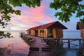 Beautiful sunset above typical water bungalows on the beach - Waigeo Island, Raja Ampat, West Papua, Indonesia Royalty Free Stock Photo