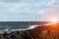 Sunset above windmills in the ocean Royalty Free Stock Photo