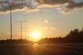 Beautiful sunset with asphalt highways road in rural scene. Large clouds in the evening sky. Royalty Free Stock Photo