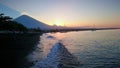 Beautiful sunset in the bay of Amed, vulcano, sea, reflecting sun, waves beach Bali