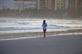 Beautiful sunset on the beach. A beautiful girl alone walking on the beach sand at dusk. Golden sunset light over the entire envir