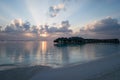Beautiful sunset on the beach overlooking the water bungalows in Maldives