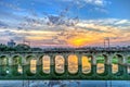 Beautiful Sunset behind an old stone arched rail bridge reflection and nice sky colors background Royalty Free Stock Photo