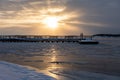 Beautiful sunset behind a pier in frozen sea in Ruissalo, Turku, Finland Royalty Free Stock Photo