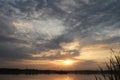 Beautiful sunset cloudy blue bright sky and golden light with silhouette tree reflect on calm water in the lake Royalty Free Stock Photo