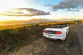 Beautiful sunset on coastal road of Maui with convertible