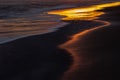 Beautiful sunset at the edge of the sea. The sky and the sand are covered with golden reflections Royalty Free Stock Photo