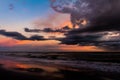 Beautiful sunset at the edge of the sea. The sky and the sand are covered with golden reflections Royalty Free Stock Photo