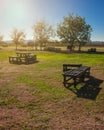 Beautiful sunset in the forest, camping place without people with wooden tables, summer vacation, blue sky Royalty Free Stock Photo