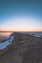 Sunset on the pier by the frozen Baltic sea