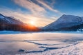 Beautiful sunset, a frozen lake and snow-capped mountains. Royalty Free Stock Photo