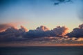 Seascape with beautiful sunset glowing orange under dramatic clouds over the Pacific Ocean