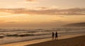 Beautiful sunset on Karon beach. The surf pounds the shore. Dark dim silhouettes of a man and a woman walking arm in arm along sur Royalty Free Stock Photo
