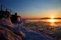 Beautiful sunset on Lake Baikal. On the pier, a man and a woman watch the sunset. Melting ice in the lake. Royalty Free Stock Photo