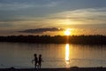 sunset on the lake with children silhouettes