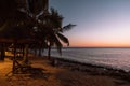 Beautiful sunset landscape on the beach with empty sunbeds. Tropical vacation